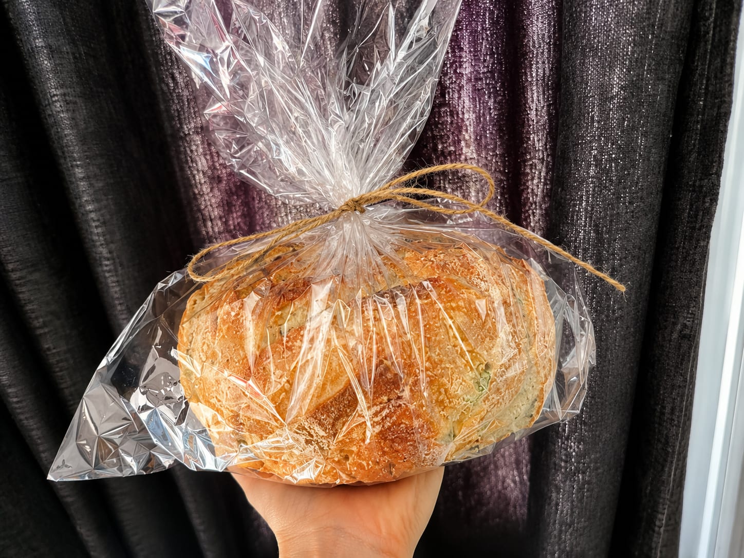 Sourdough loaf in a clear bag tied with twine