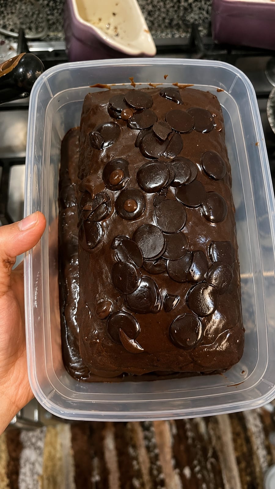 Chocolate loaf topped with chocolate discs in a clear container