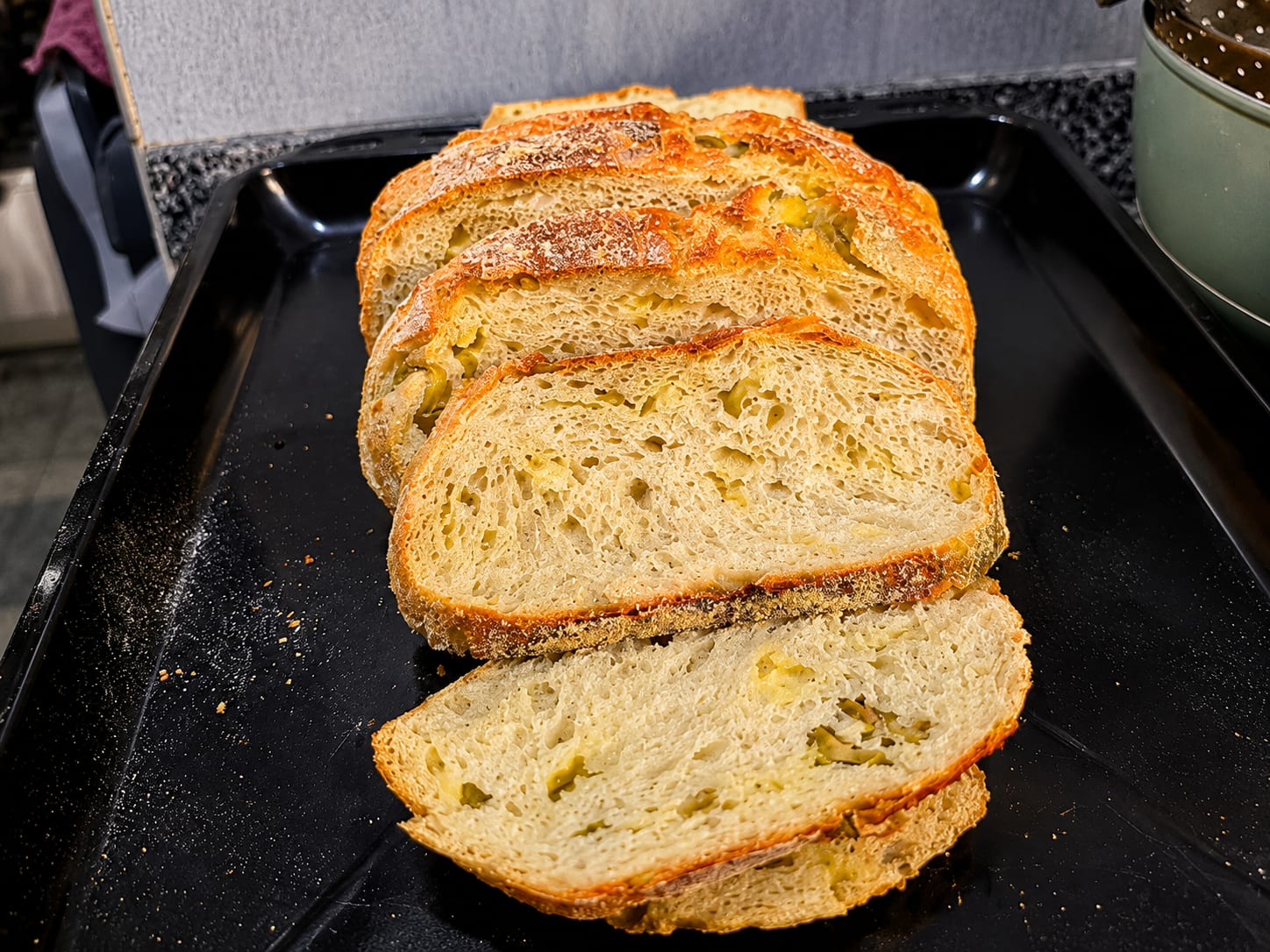 Freshly sliced olive sourdough bread showing the open crumb