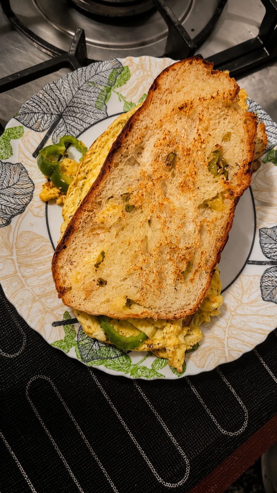 Toasted sourdough slice served over eggs and green pepper