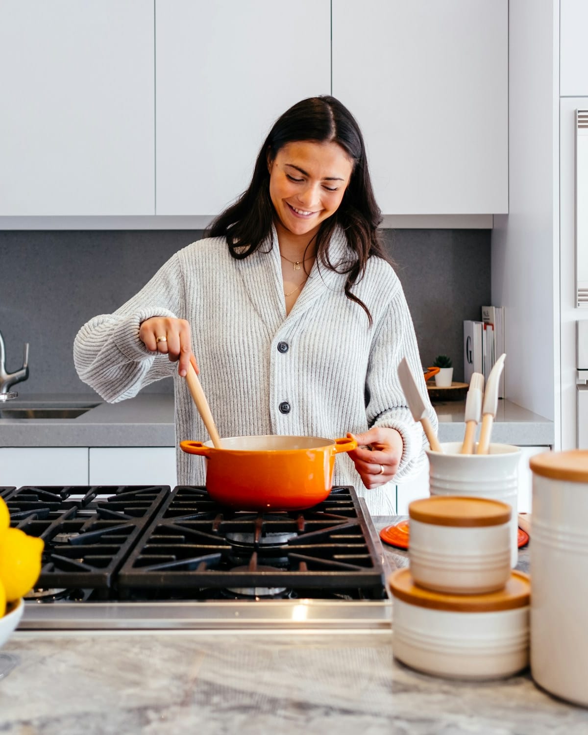 Woman stirring a pot on the stove in a kitchen